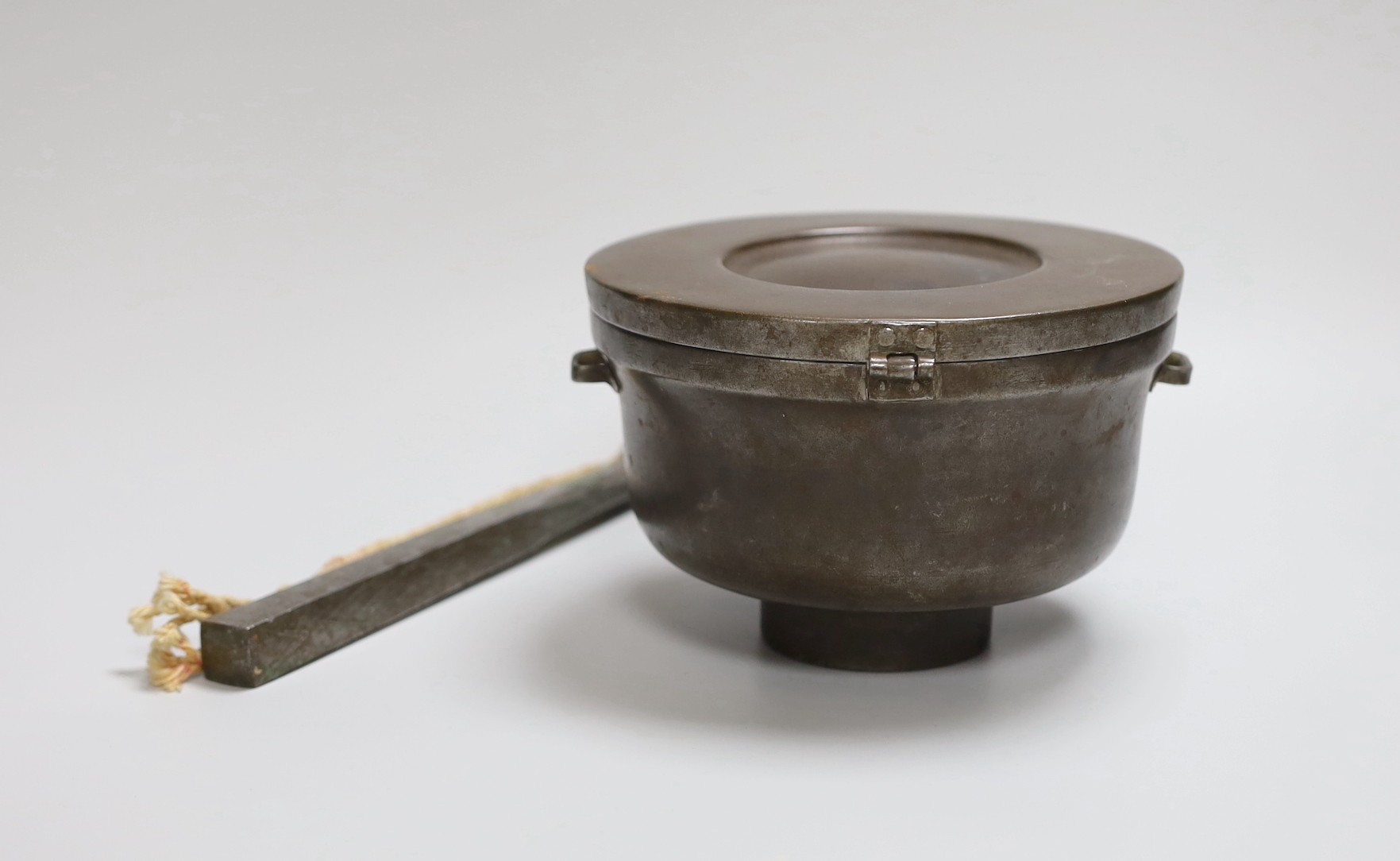 A Tibetan stunning weight, 21cm, and a Tibetan saddle storage pot